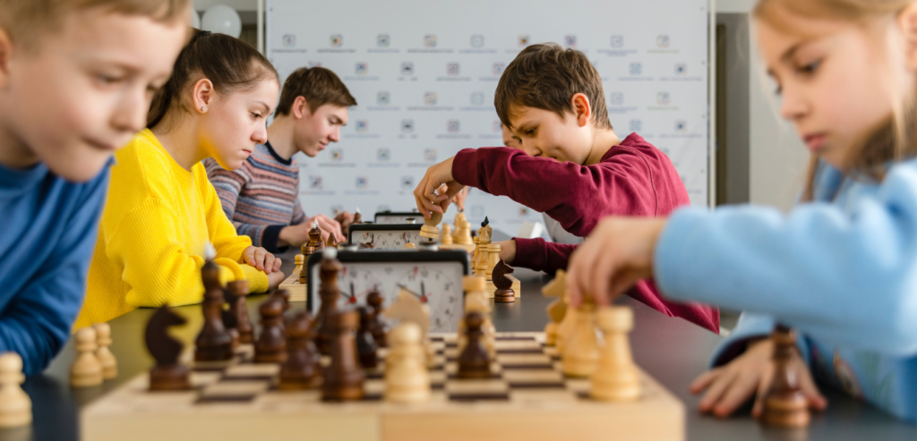 Students in a school chess club focused on a game, enhancing academic skills